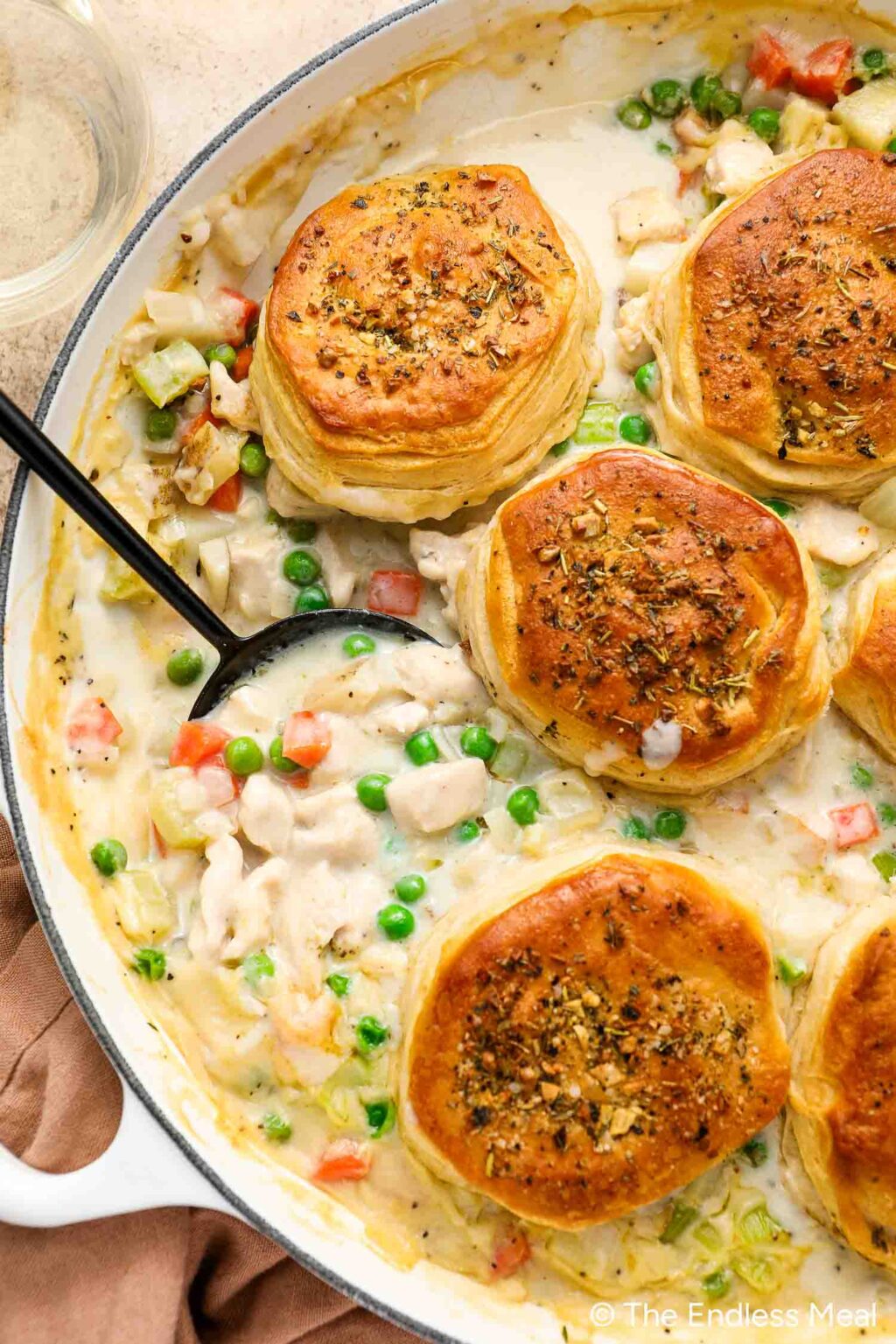 A skillet filled with creamy Chicken Pot Pie with Biscuits, brimming with tender chicken and vegetables, all crowned by golden-brown herb biscuits.