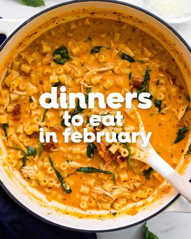 A pot of creamy pasta with chicken, spinach, and sun-dried tomatoes—one of the coziest dinners to eat in February. Text overlay reads, Dinners to Eat in February.